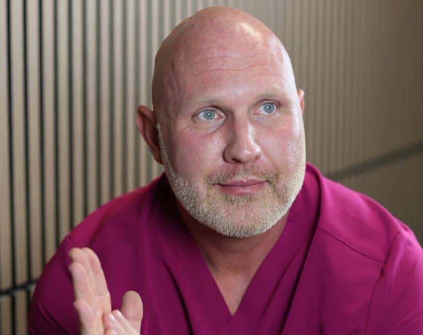 Dr. Kaleb Falk, ND, Kamloops-based naturopathic doctor, seated in clinic and speaking with a patient