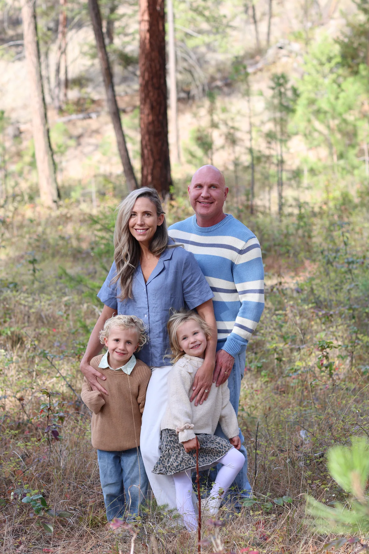 Dr. Kaleb Falk and Dr. Marissa Gaucher smiling outdoors with their two children.
